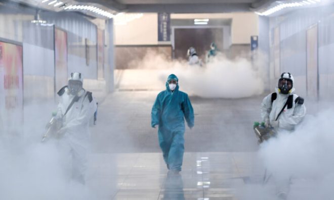 Volunteers in protective suits disinfect a railway station as the country is hit by an outbreak of the new coronavirus, in Changsha